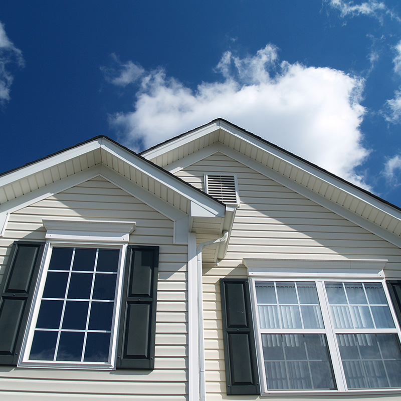 Closeup of Suburban Home with bright blue sky and white clouds